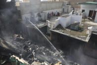 Fire brigade staff try to put out fire caused by plane crash in Karachi, Pakistan, Friday, May 22, 2020. An aviation official says a passenger plane belonging to state-run Pakistan International Airlines carrying more than 100 passengers and crew has crashed near the southern port city of Karachi. There were no immediate reports on the number of casualties. (AP Photo/Fareed Khan)