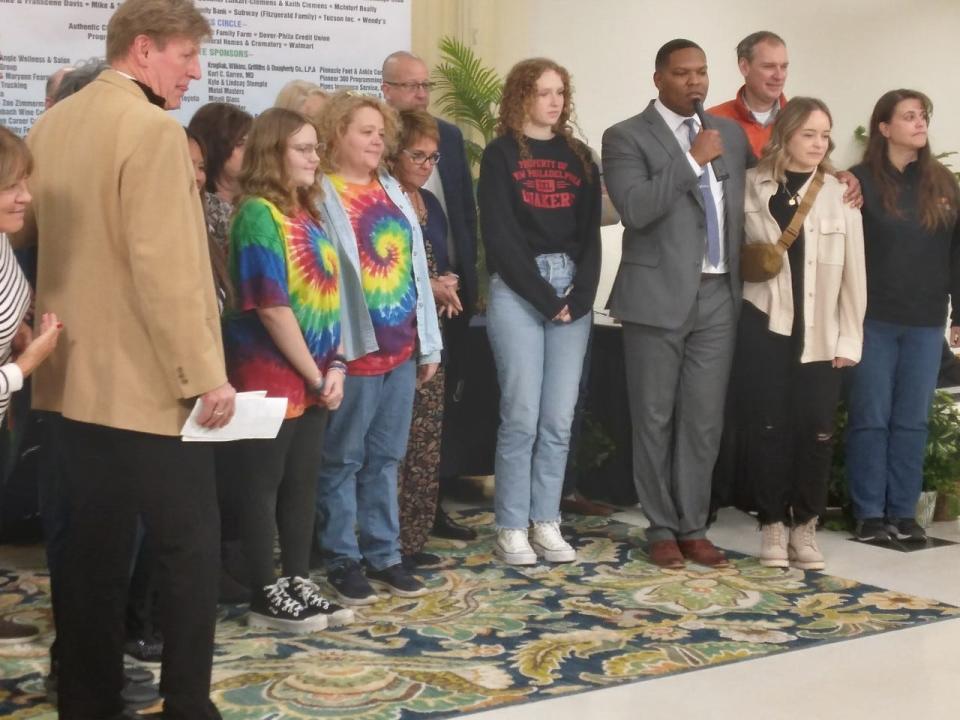 Rainbow Connection Executive Director Perci Garner (with microphone) stands  with volunteers and staff at the end of the charity's 50th annual telethon on Sunday.