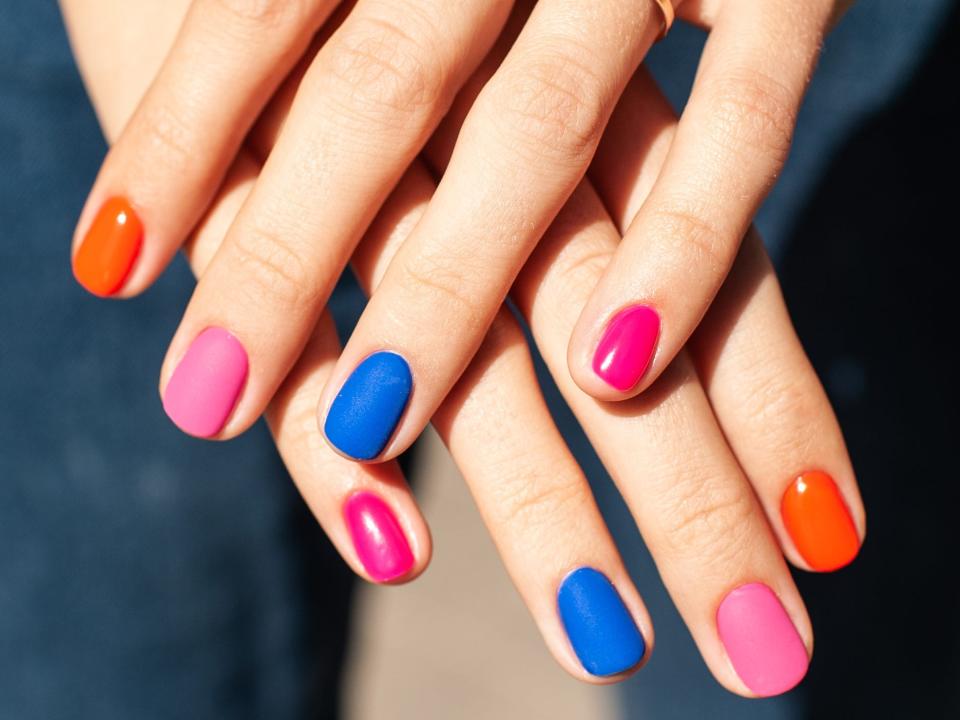 Bright manicure design with multi-colored nail polish.