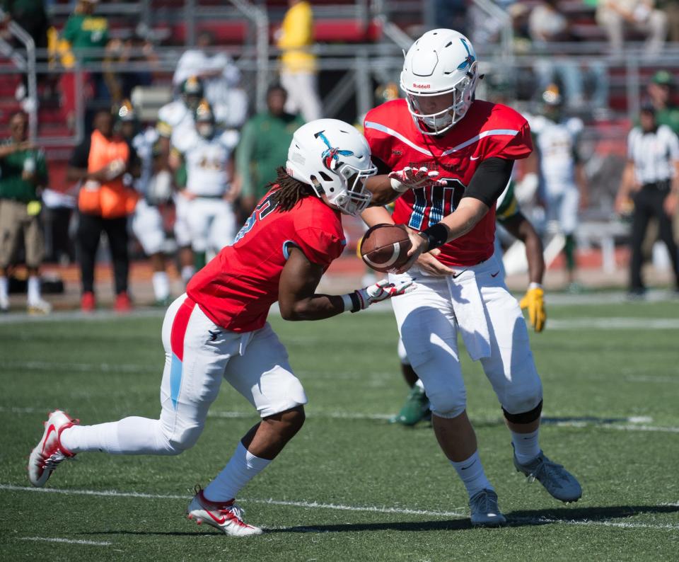 Delaware State's quarterback, Jack McDaniels (10) hands off the ball to running back Brycen Alleyne (6) in the first quarter against Norfolk State in 2017.
