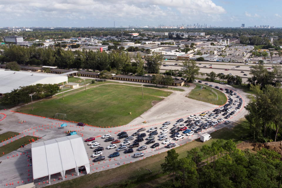 Cars wait in line at a COVID-19 drive-through testing site in Miami on Friday. (Marco Bello/Reuters)