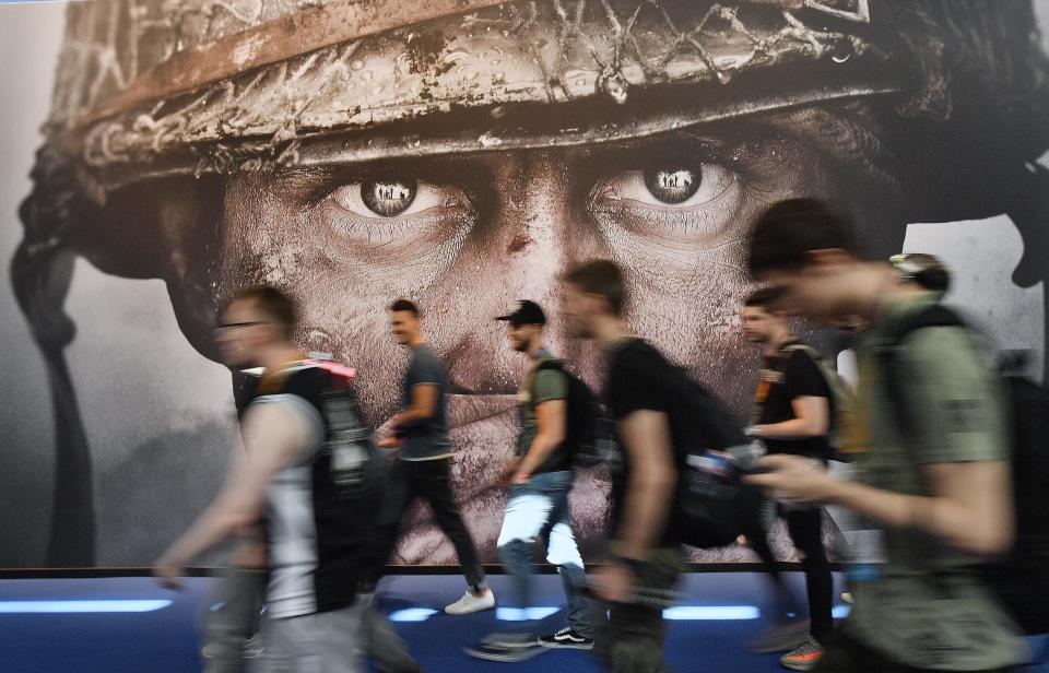 FILE - Visitors passing an advertisement for the video game 'Call of Duty' at the Gamescom fair for computer games in Cologne, Germany, Tuesday, Aug. 22, 2017. British regulators have blocked Microsoft's $69 billion deal to buy videogame maker Activision Blizzard over worries that it would stifle competition in the cloud gaming market. (AP Photo/Martin Meissner, File)