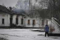 A local resident walks past a school that was damaged by Russian shelling the town of Orekhovo in Zaporizhzhya region, Ukraine, Monday, Jan. 30, 2023. (AP Photo/Andriy Andriyenko)