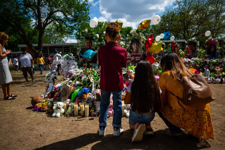 Zayin Zuniga visits Eliahna Amyah Garcia’s memorial, left, on June 1. Flowers and balloons surround crosses at Robb Elementary in Uvalde. (Kaylee Greenlee Beal/The Texas Tribune)