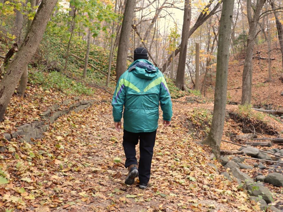A man walks a trail in the fall