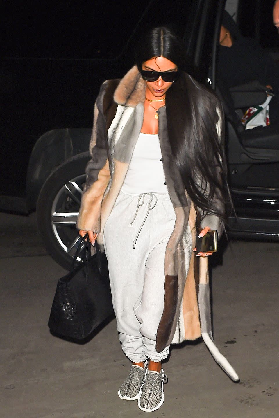 <p>In a color-blocked fur coat, light grey top and sweatpants, Yeezy sneakers, alligator tote bag, and sunglasses while arriving in NYC</p>