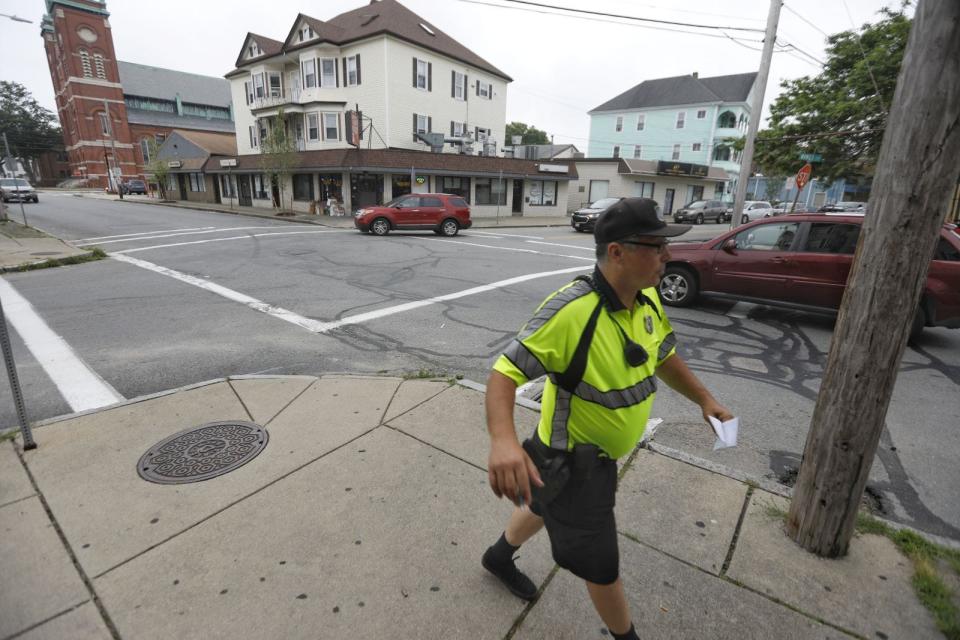 New Bedford police officer Mike Doyle walks by the intersection of Rivet and Orchard streets in New Bedford where a New Bedford police officer was shot Monday night.