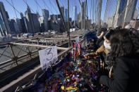 Pedestrians shop at vendors selling souvenirs on the Brooklyn Bridge in New York, Tuesday, Jan. 2, 2024. New York City will ban vendors from the Brooklyn Bridge starting Wednesday, Jan. 3, 2024. The move is intended to ease overcrowding on the famed East River crossing, where dozens of souvenir sellers currently compete for space with tourists and city commuters. (AP Photo/Seth Wenig)