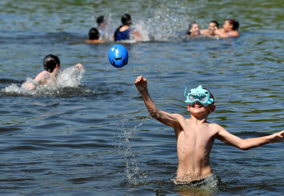 In May, Gable Castine, 8, of Auburn tosses a football while playing in the water at Coes Pond Beach.