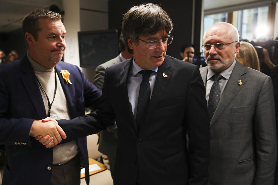 Catalonia's former regional president Carles Puigdemont, center, arrives to give a statement in Brussels, Monday, Oct. 14, 2019. A dozen Catalan politicians and activists have been convicted on charges of sedition, misuse of public funds and disobedience for their role in an illegal and failed secession attempt for the northeastern region of Spain in 2017. (AP Photo/Francisco Seco)