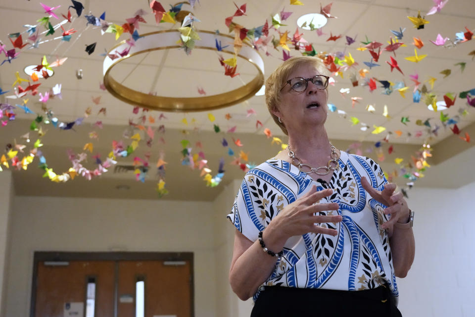 Trudy Waters, the Head of School at The Covenant School in Nashville, Tenn., talks about changes and improvements made at the school on Tuesday, June 25, 2024. Above her are strings of origami cranes sent by people around the country who were moved by the tragedy at this Christian elementary school. The school reopened in April 2024, a little over a year after three students and three adults were killed in a shooting at the school. (AP Photo/Mark Humphrey)