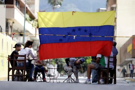 People are seen behind a barricade during a strike called to protest against Venezuelan President Nicolas Maduro's government in Caracas, Venezuela July 26, 2017. REUTERS/Ueslei Marcelino