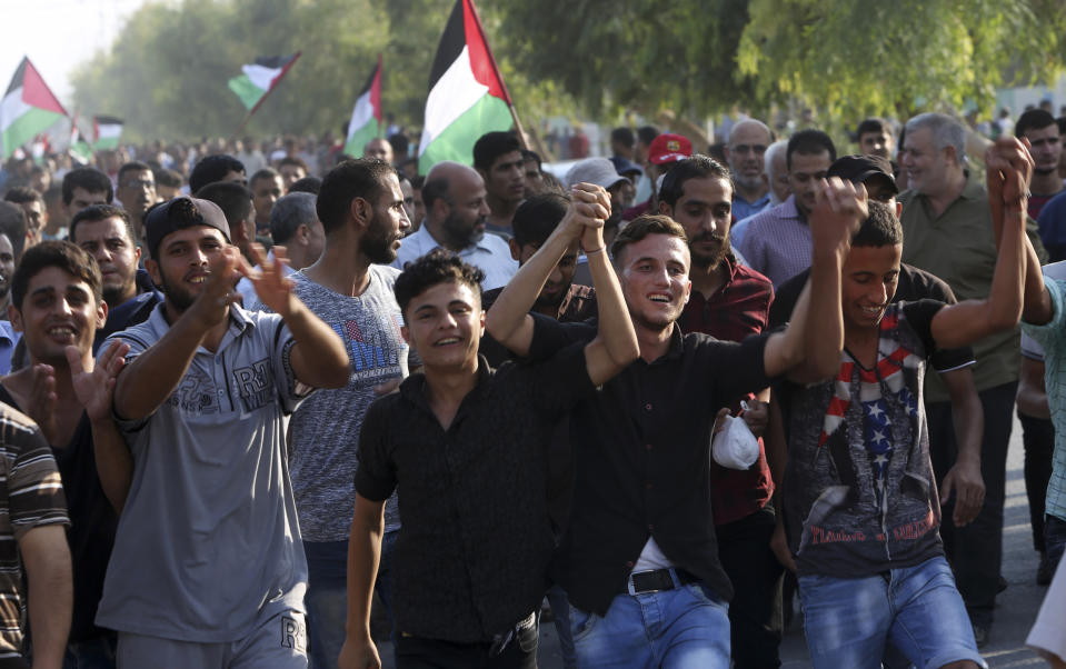 Protesters chant slogans during a protest at the Palestinians side of Erez border crossing between Gaza and Israel, in Beit Hanoun, northern Gaza Strip, Tuesday, Sept. 4, 2018. The Health Ministry in Gaza says several Palestinians were wounded by Israeli fire as they protested near the territory's main personnel crossing with Israel. (AP Photo/Adel Hana)