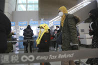 Passengers wear masks in a departure lobby at Incheon International Airport in Incheon, South Korea, Monday, Jan. 27, 2020. China on Monday expanded sweeping efforts to contain a viral disease by extending the Lunar New Year holiday to keep the public at home and avoid spreading infection. (AP Photo/Ahn Young-joon)