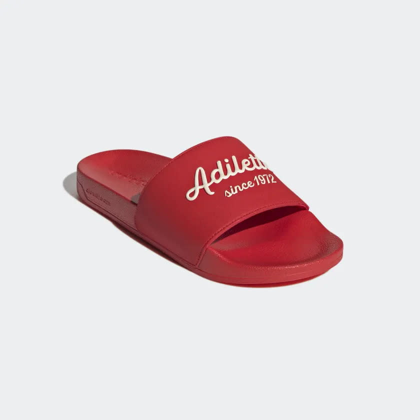 Red slides with Adilette and Since 1972 written across in cream.