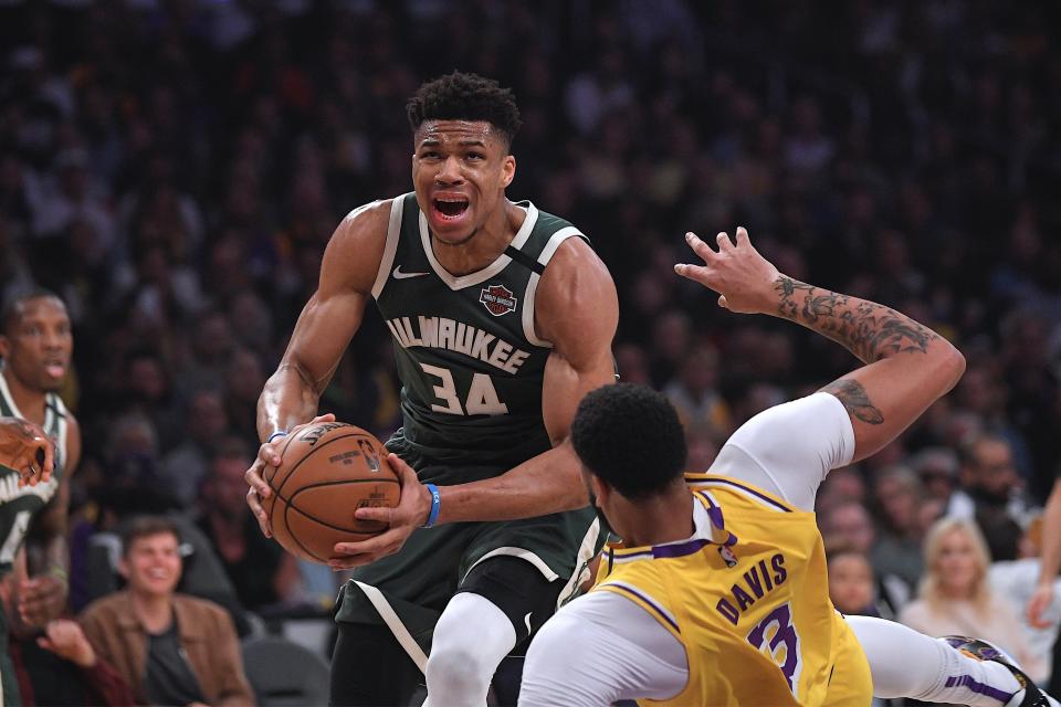 Milwaukee Bucks forward Giannis Antetokounmpo, knocks down Los Angeles Lakers forward Anthony Davis as he drives to the basket during the first half of an NBA basketball game Friday, March 6, 2020, in Los Angeles. (AP Photo/Mark J. Terrill)