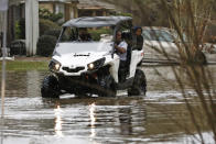 Area residents use a high-water ATV to ride through the Pearl River floodwaters on North Canton Club Circle in Jackson, Miss., Tuesday, Feb. 18, 2020. Officials have limited entry to the flooded neighborhoods as they have warned residents about the contamination of the receding waters and the swift currents. (AP Photo/Rogelio V. Solis)