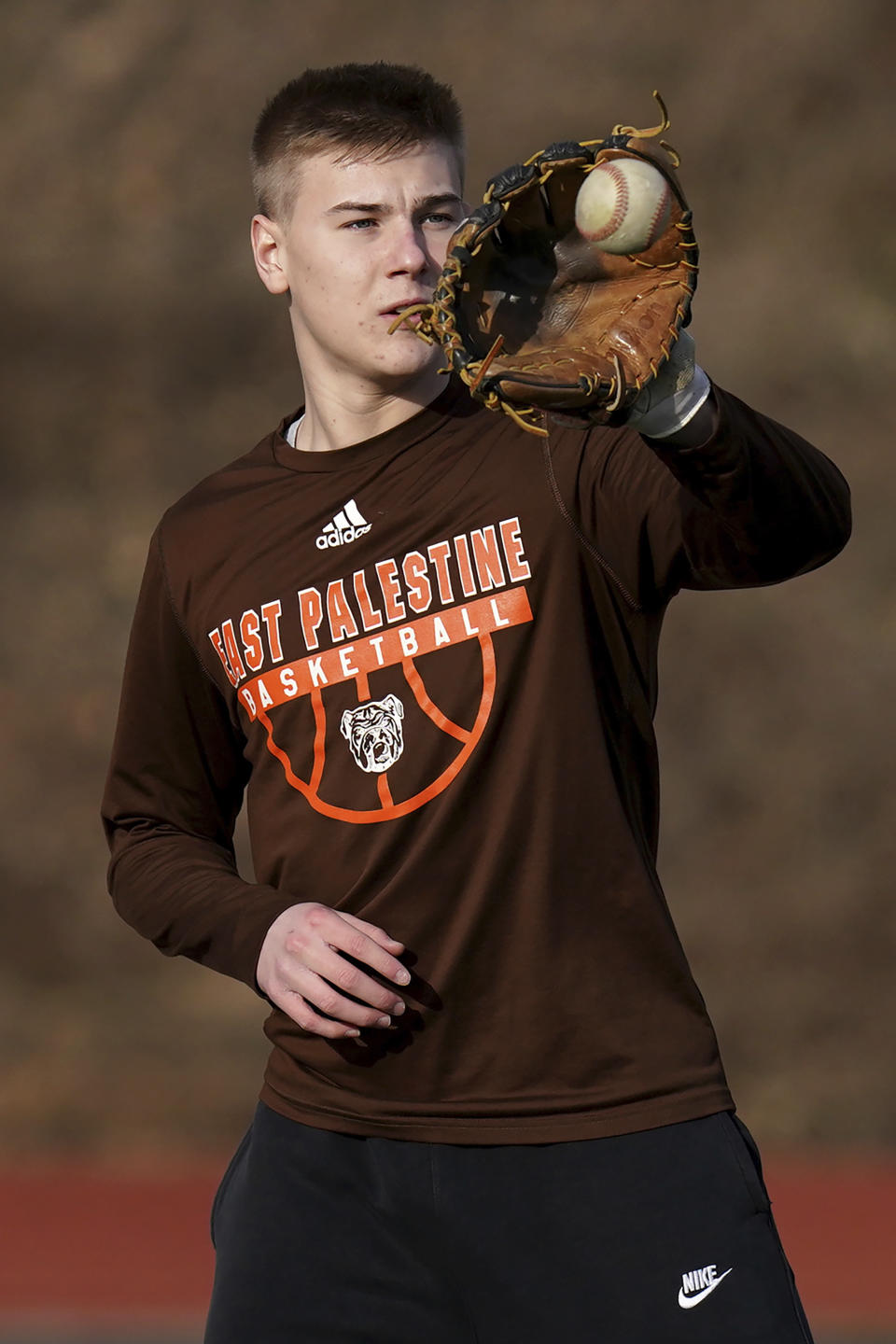 East Palestine High School senior Owen Elliott pulls in a ball during baseball practice, Monday, March 6, 2023, in East Palestine, Ohio. Athletes are navigating spring sports following the Feb. 3 Norfolk Southern freight train derailment. (AP Photo/Matt Freed)