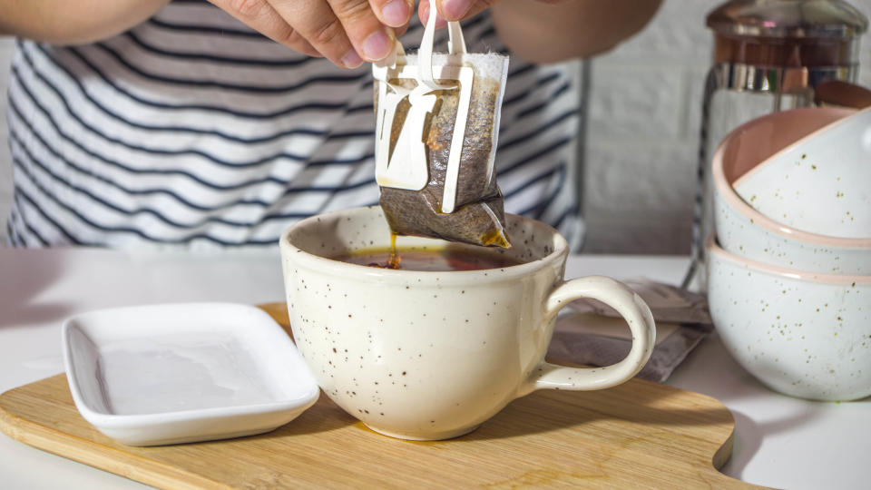 Coffee filter bag being squeezed in a cup