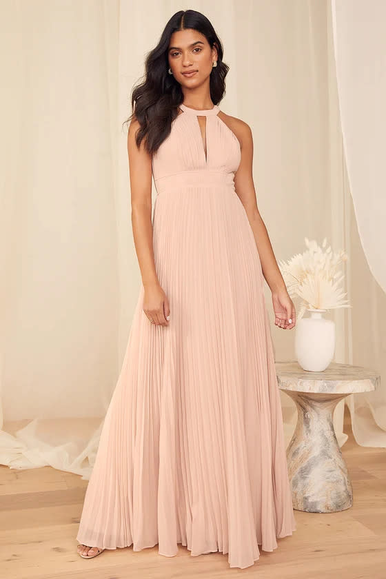 model with black hair posing in light pink halter neck bridesmaids dress 