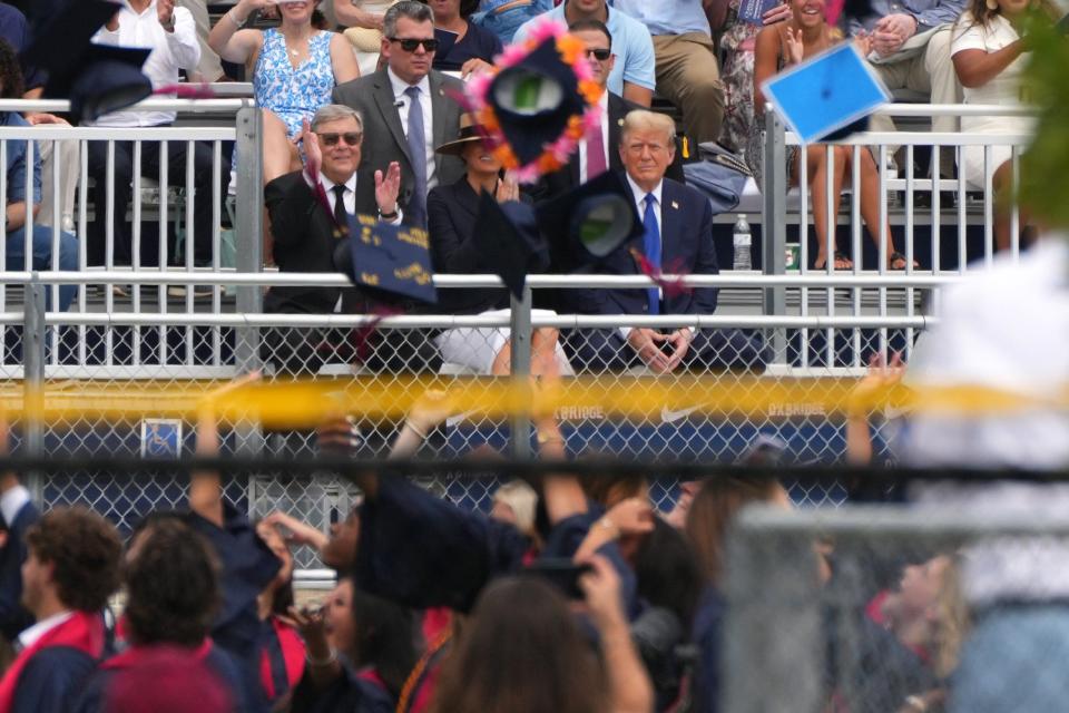 Graduation caps fly as former President Trump and wife Melania attend the high school graduation ceremony of their son, Barron, at Oxbridge Academy on Friday, May 17, 2024 in West Palm Beach.