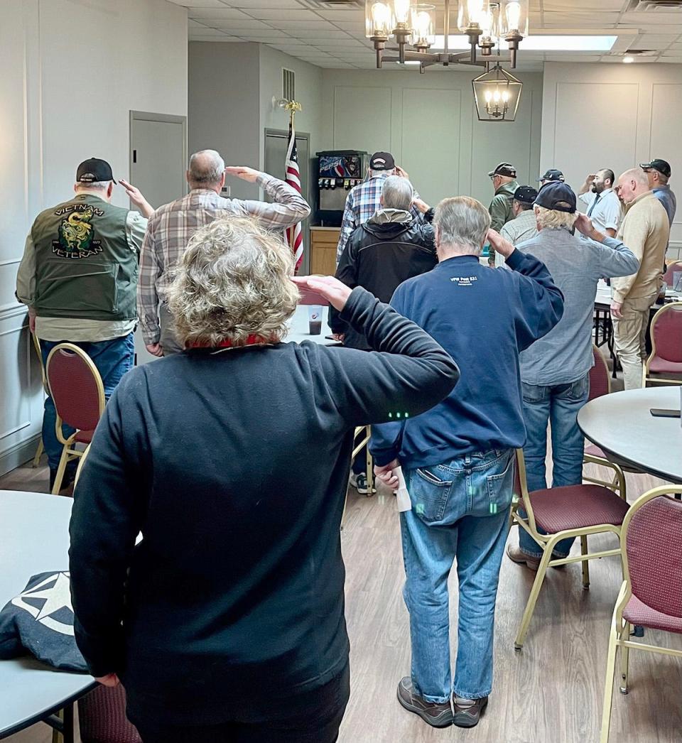Local veterans salute the flag just before the start of a meeting at Elegante in Honesdale. The event was organized to honor those who served their country in Vietnam.