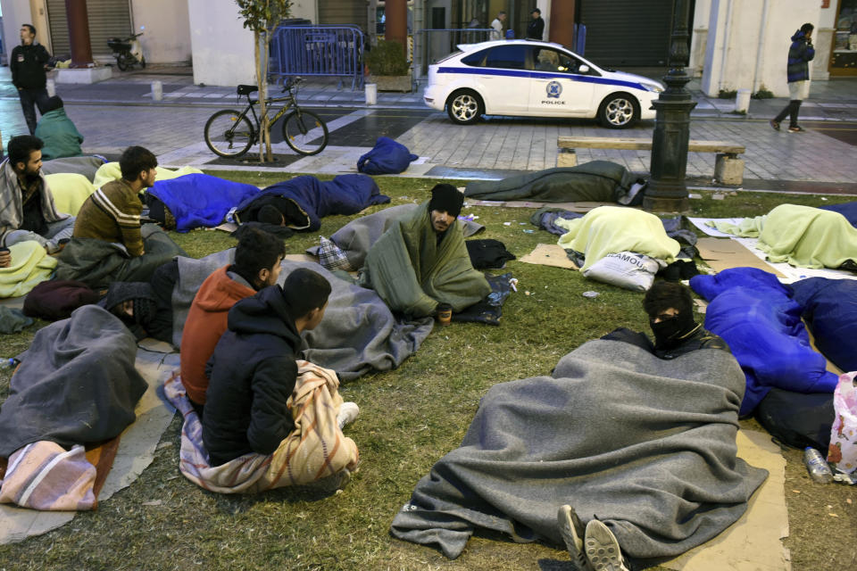 Kurdish migrants wait outside a police station in Aristotelous Square at the northern Greek city of Thessaloniki, Monday, Oct. 8, 2018. Dozens of refugees and migrants have gathered outside a police station in Greece's second largest city, waiting for hours to be formally arrested and gain temporary residence in the European Union country. (AP Photo/Giannis Papanikos)