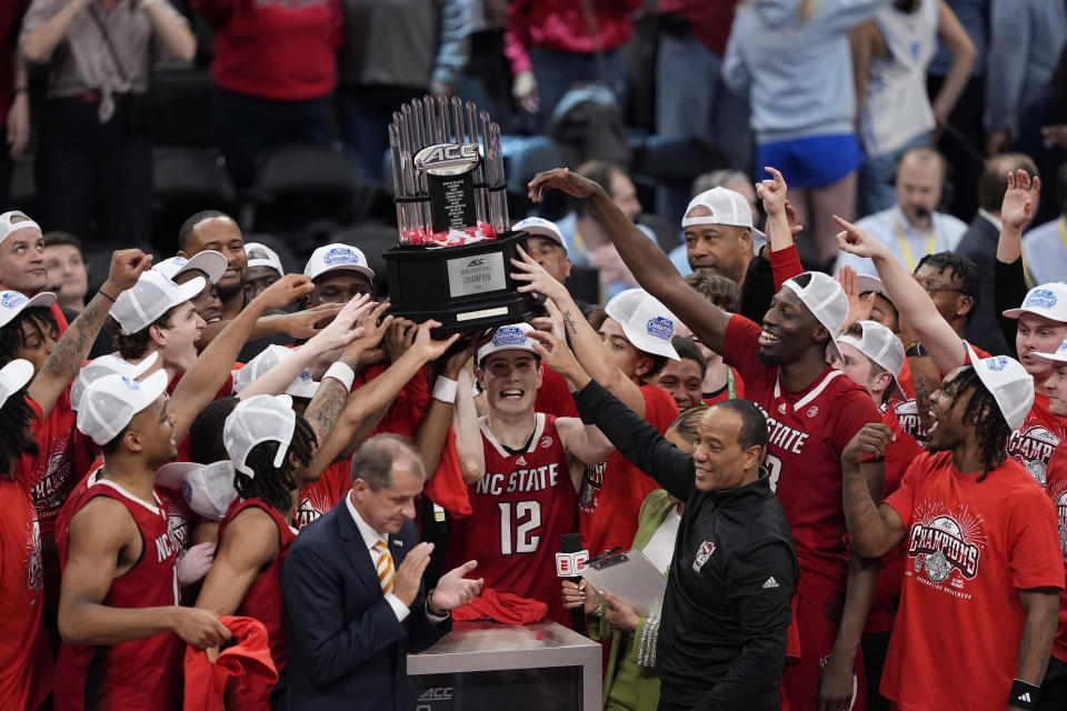 North Carolina State guard Michael O'Connell (12) and his teammates hoist the trophy after winning an NCAA college basketball game against North Carolina to win the championship of the Atlantic Coast Conference tournament, Saturday, March 16, 2024, in Washington. North Carolina State won 84-76. (AP Photo/Susan Walsh)