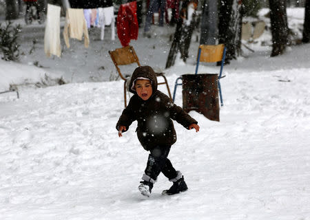 A stranded Syrian refugee boy cries as he braves through a showstorm at a refugee camp north of Athens January 10, 2017.REUTERS/Yannis Behrakis