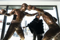 Weatta Frazier Collins kisses a statue of her father Joe Frazier, right, fighting Muhammad Ali, on the 50th anniversary of the boxers' World Heavyweight championship boxing bout, at the Joe Hand Gym in Feasterville, Pa., Monday, March 8, 2021. (AP Photo/Matt Rourke)