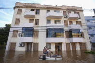 A man rows a makeshift boat through an inundated street flooded by heavy rains, in Porto Alegre, Brazil, Tuesday, May 7, 2024. (AP Photo/Andre Penner)