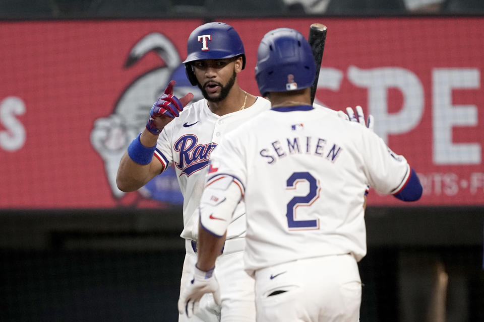 Texas Rangers' Leody Taveras, left, and Marcus Semien (2) celebrate after Semien hit a two-run home run that also scored Taveras against the Tampa Bay Rays in the seventh inning of a baseball game in Arlington, Texas, Saturday, July 6, 2024. (AP Photo/Tony Gutierrez)