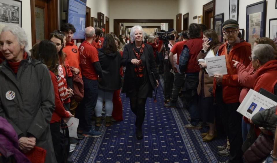 Rep. Louise Stutes, R-Kodiak, is surrounded by education advocates as she enters the House chambers before a veto override vote on Senate Bill 140 on Monday, March 18, 2024. Stutes voted yes on the override, which failed by a single vote. (Photo by James Brooks/Alaska Beacon)