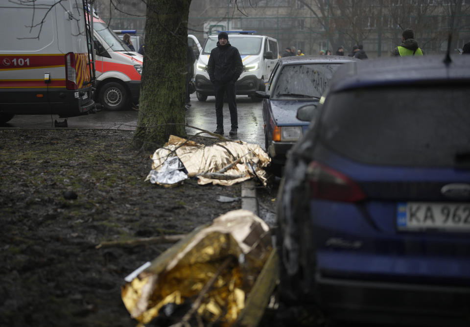 Dead bodies lay on the ground at the scene where a helicopter crashed on civil infrastructure in Brovary, on the outskirts of Kyiv, Ukraine, Wednesday, Jan. 18, 2023. The chief of Ukraine's National Police says a helicopter crash in a Kyiv suburb has killed 16 people, including Ukraine's interior minister and two children. He said nine of those killed were aboard the emergency services helicopter. (AP Photo/Daniel Cole)