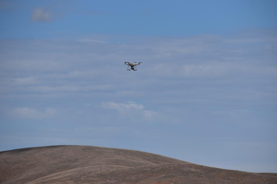A small drone hovers above the firing range.