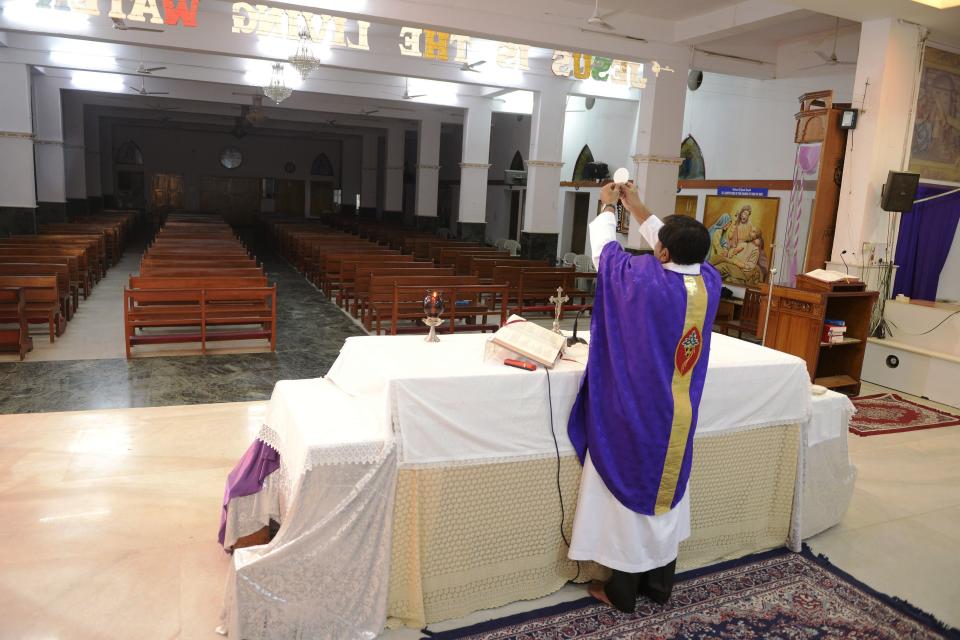 A Catholic priest celebrates a private mass at Saint Joseph's Church, due to the closure of all church services during a one-day Janata (civil) curfew imposed amid concerns over the spread of the COVID-19 novel coronavirus, in Secunderabad, the twin city of Hyderabad, on March 22, 2020. (Photo by NOAH SEELAM / AFP) (Photo by NOAH SEELAM/AFP via Getty Images)