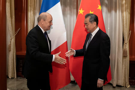 China's Foreign Minister Wang Yi shakes hands with his French counterpart Jean-Yves Le Drian at Diaoyutai State Guesthouse in Beijing, China April 25, 2019. Nicolas Asfouri/Pool via REUTERS