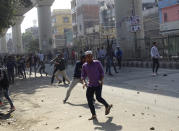 A group of protestors clash with another group in New Delhi, India, Monday, Feb. 24, 2020. Indian paramilitary troops used tear gas and smoke grenades to disperse a crowd of clashing protesters in New Delhi on Monday as violence broke out over a new citizenship law just ahead of U.S. President Donald Trump’s visit to the city. (AP Photo/Dinesh Joshi)