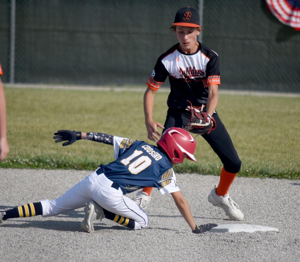Levi Cousino of Ash Carleton Gold dives back to second base after he hit a double in the 63rd annual Monroe County Fair Baseball Tournament Tuesday. Kaiden Raymo of Summerfield covers the base.
