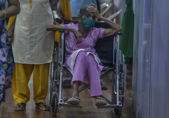 An elderly woman waits to receive the vaccine for COVID-19 at a vaccination center in Mumbai, India, Sunday, April 18, 2021. India has been overwhelmed by hundreds of thousands of new coronavirus cases daily, bringing pain, fear and agony to many lives as lockdowns have been placed in Delhi and other cities around the country. (AP Photo/Rafiq Maqbool)