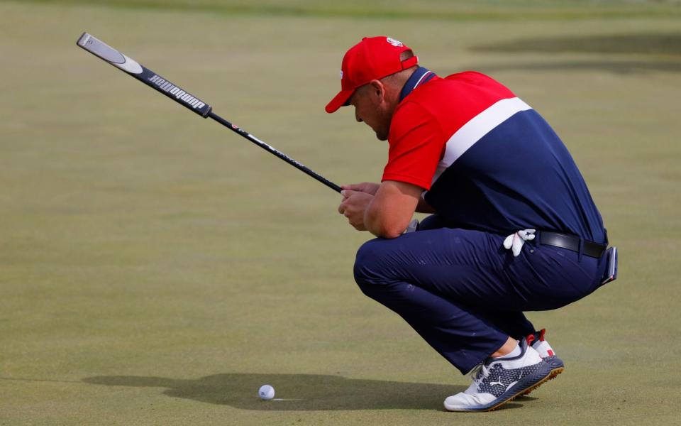 Bryson DeChambeau lines up a putt - REUTERS