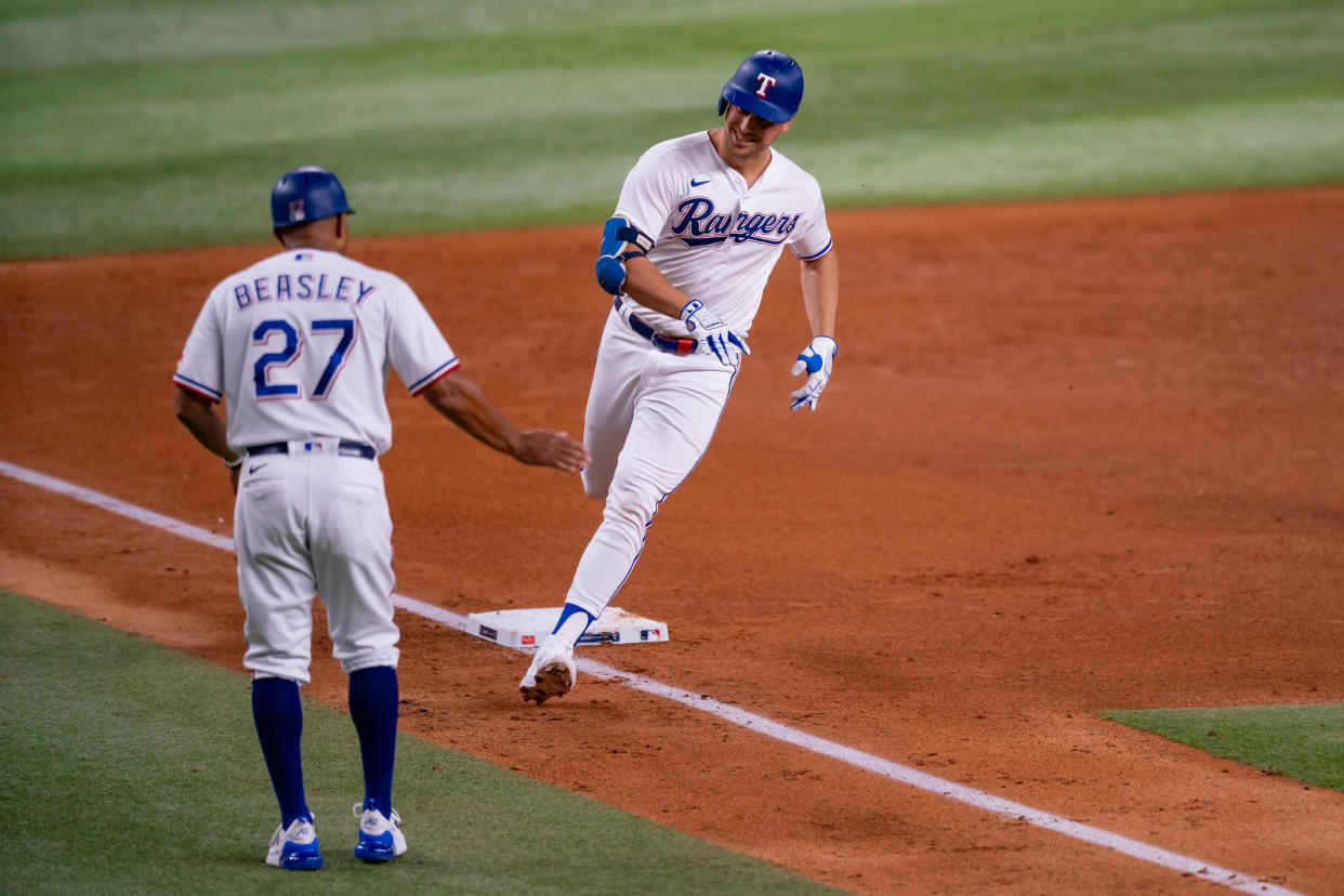Base runners look to third-base coaches, such as the Texas Rangers' Tony Beasley, for the critical decision of whether to stop at third or sprint for home. (Chris Leduc/Icon Sportswire via Getty Images)