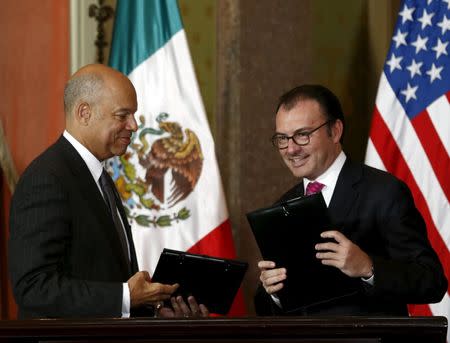 U.S. Department of Homeland Security (DHS) Secretary Jeh Johnson (L) and Mexico's Finance Minister Luis Videgaray exchange documents after signing an agreement to announce a program of pre-inspection border stations during a news conference in Mexico City, Mexico October 15, 2015. REUTERS/Henry Romero