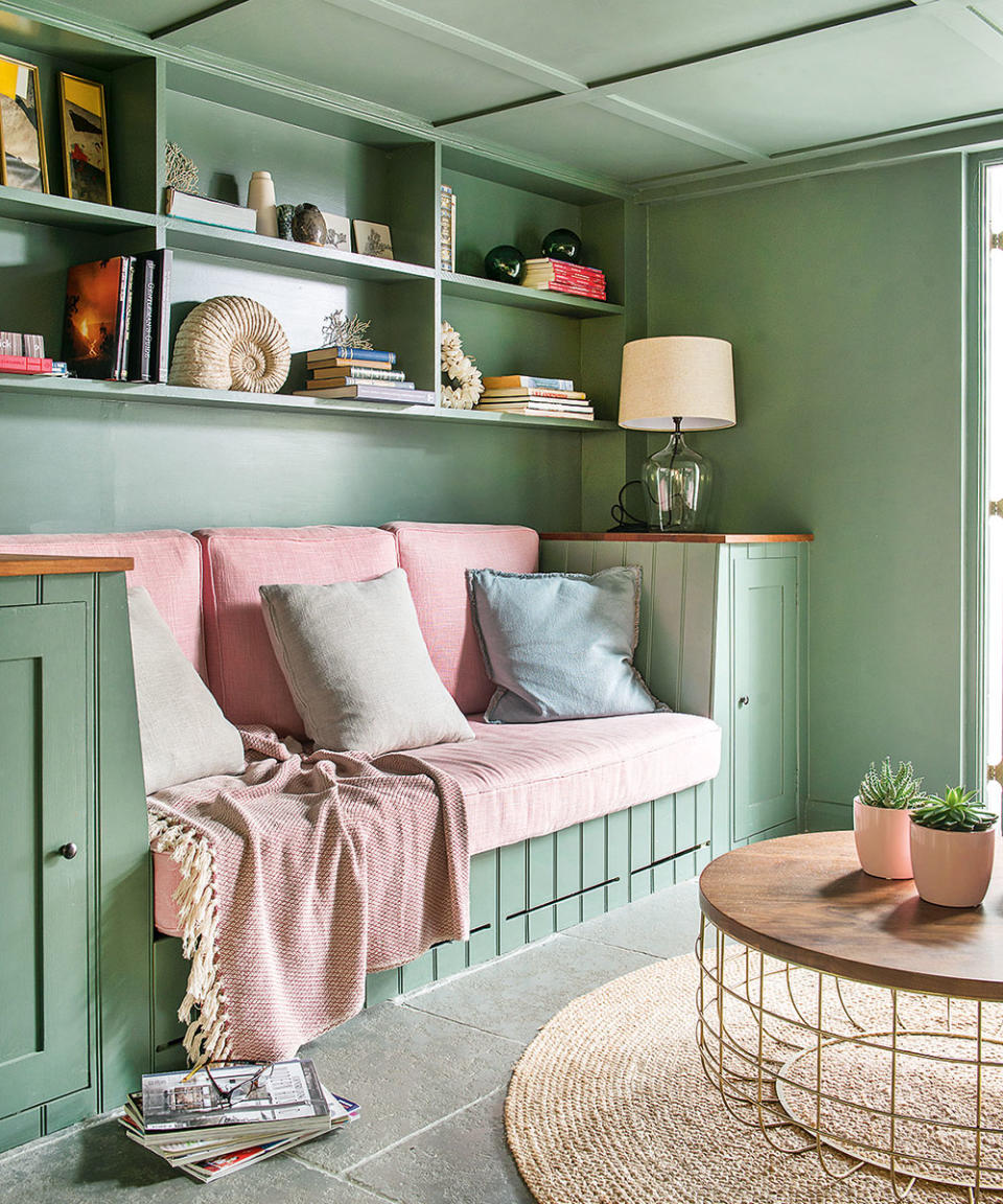 living room with storage painted green with pink cushions