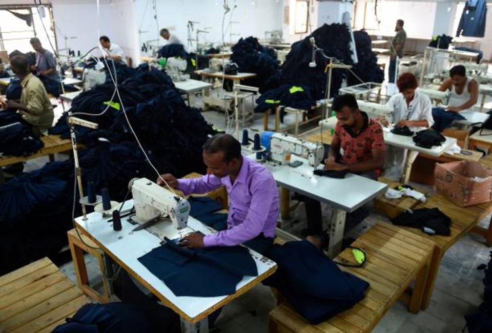 File: Pakistani workers stitch cloths at a garment factory in Karachi on 15 July 2019 (AFP via Getty Images)