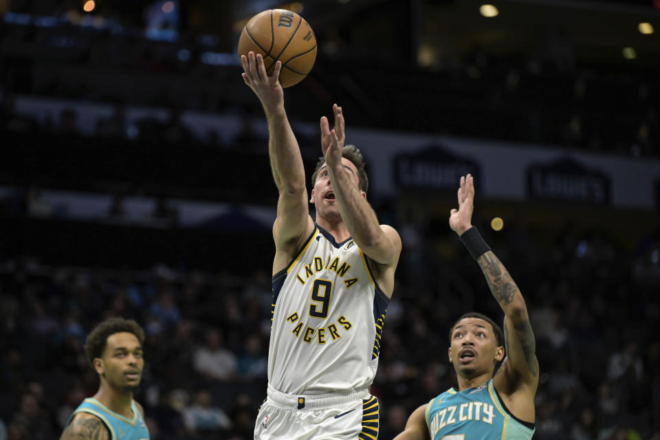 Indiana Pacers guard T.J. McConnell (9) drives past Charlotte Hornets guard Nick Smith Jr., right, during the first half of an NBA basketball game, Sunday, Feb. 4, 2024, in Charlotte, N.C. (AP Photo/Matt Kelley)