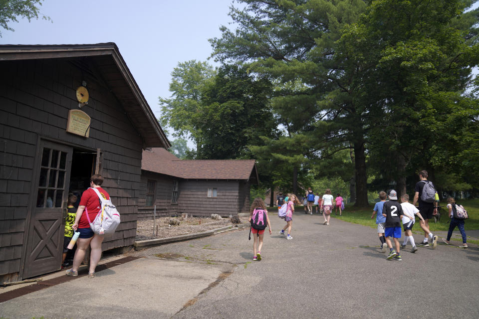 Children walk across the campground through smokey haze to their next indoor activity at the YMCA Camp Kon-O-Kwee Spencer in Zelienople, Pa., on Thursday, June 29, 2023. Due to the poor air quality caused by the Canadian wildfires the Western Pennsylvania summer camp closed its outdoor pool and sent home a few campers with health problems. (AP Photo/Jessie Wardarski)