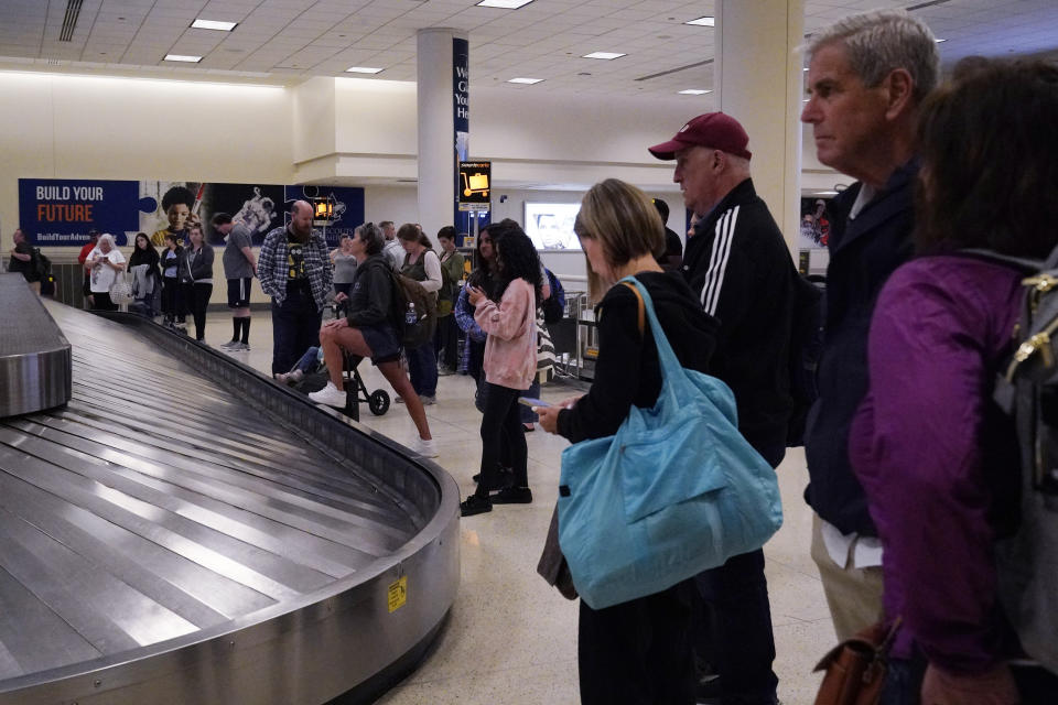 Travelers wait for their luggage at Midway International Airport in Chicago, Wednesday, July 12, 2023. A tornado touched down Wednesday evening near Chicago’s O’Hare International Airport, prompting passengers to take shelter and disrupting hundreds of flights. (AP Photo/Nam Y. Huh)