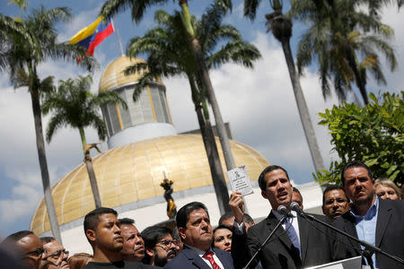 Juan Guaido, President of Venezuela's National Assembly, holds a copy of the National Constitution while he speaks during a news conference in Caracas, Venezuela January 21, 2019. REUTERS/Manaure Quintero