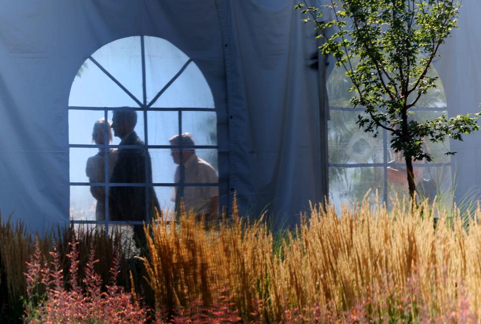 People are seen in a window of a tent as they make their way in for the one of two sessions for the dedication of the Saratoga Springs Utah Temple in Saratoga Springs, Utah, on Sunday, Aug. 13, 2023. | Scott G Winterton, Deseret News